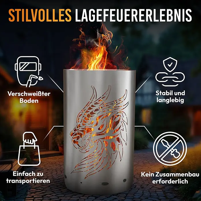 TiKo-Design Holzkohlegrill Feuertonne-Drachen - grau - Zylindrische Edelstahl-Feuerstelle mit einem Drachenausschnitt-Design, brennend mit Flammen in einem Garten.