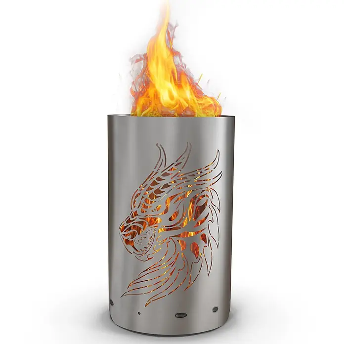 TiKo-Design Holzkohlegrill Feuertonne-Drachen - grau - Zylindrische Edelstahl-Feuerstelle mit Drachenmotiv-Ausschnitten, durch die und oben helle Flammen lodern.