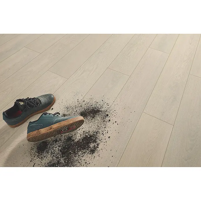 LOGOCLIC Aquaprotect Laminat - Mistery Oak, Landhausdiele, 1.288 x 195 x 8 mm - Heller Holzboden mit schmutzigen Schuhen und verstreuter Erde, der seine Strapazierfähigkeit zeigt.