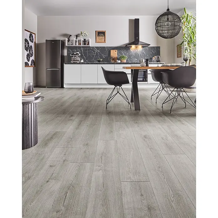 LOGOCLIC Aquaprotect Smart Silent Laminat - Calais Oak, Landhausdiele, 1.288 x 195 x 7 mm - Hellgrauer Laminatboden in Holzoptik, verlegt in einem modernen Küchen- und Essbereich.