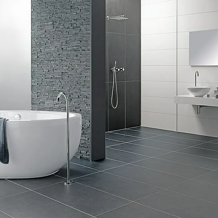 Ambiente by Palazzo Feinsteinzeugfliese - 30 x 60 cm, Schwarz, Matt - Modernes Badezimmer mit freistehender Badewanne, grauen Fliesen und stilvoller Einrichtung für ein luxuriöses Ambiente.