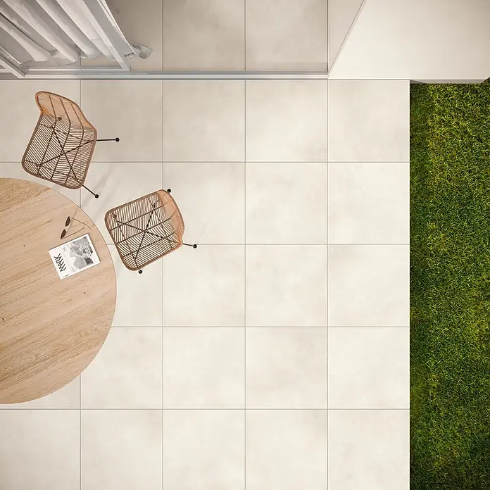 Terrassenfliese Dimension - 59,8 x 59,8 x 2 cm, Beige, Matt - Außenterrasse mit hellbeigen Fliesen, ausgestattet mit einem runden Holztisch und zwei Korbstühlen.