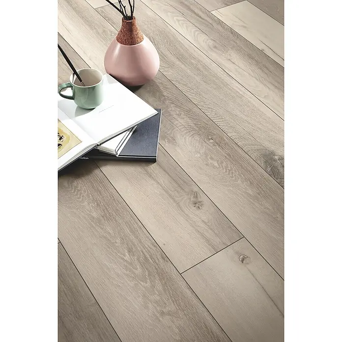 LOGOCLIC Designboden Element Flex - Eiche Alexia, Landhausdiele, 1.288 x 239 x 7 mm - Helle, beige Holzoptik-Laminatdielen diagonal verlegt, mit Dekorationsgegenständen im Vordergrund.