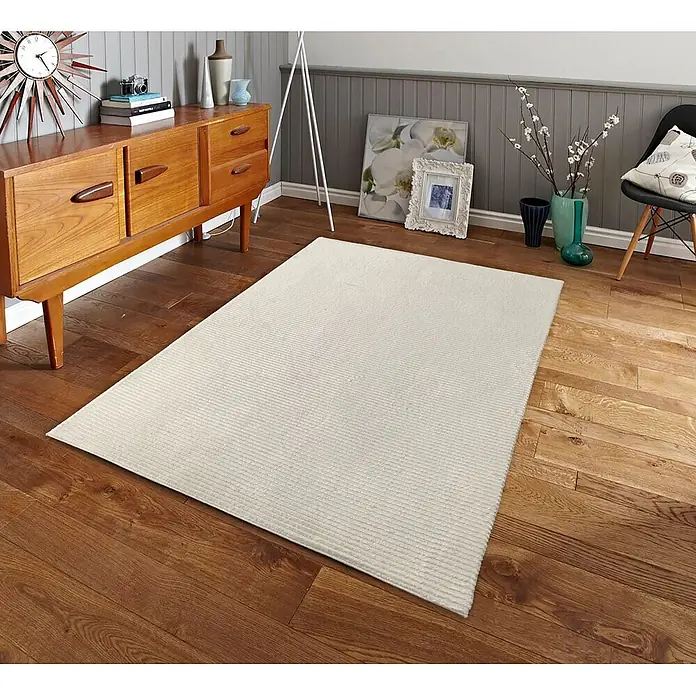 Alfombra de pelo corto Vista - Crema, 110 x 60 cm, 100% poliéster - Alfombra acanalada de color crema sobre un suelo de madera cálida en un acogedor salón.