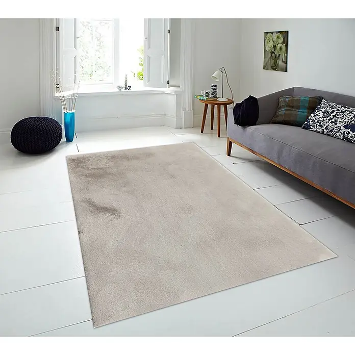 Alfombra de pelo corto Bunny - Beige, 110 x 60 cm, 100% poliéster - Alfombra suave gris claro en una sala de estar moderna con suelos de madera blancos y un sofá.