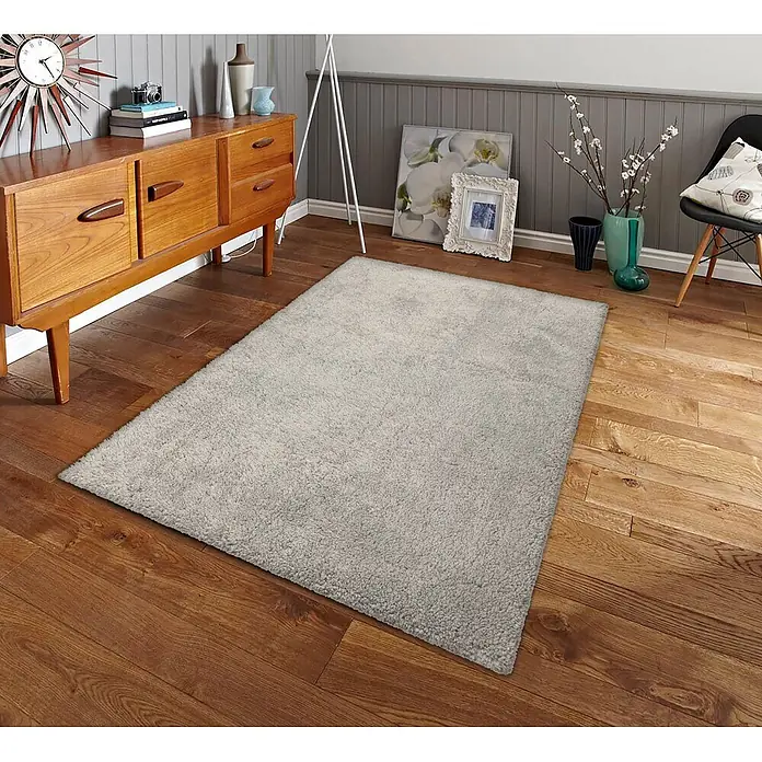 Alfombra de pelo largo Gypsy - Taupe, 110 x 60 cm, 100% Poliéster - Una alfombra gris claro de pelo largo sobre un suelo de madera en un acogedor salón.