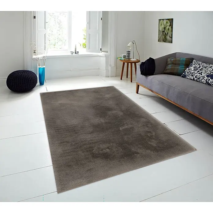 Alfombra de pelo corto Bunny - Chocolate, 110 x 60 cm, 100% poliéster - Una alfombra rectangular de pelo largo gris oscuro sobre un suelo de madera blanca en una sala luminosa.