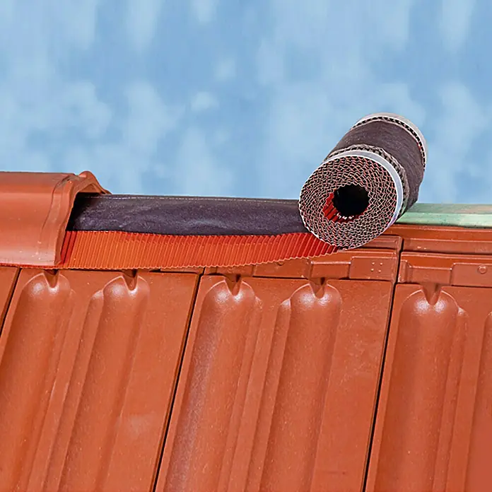 Sarei Rollfirst - 5 m x 30 cm, Ziegelrot - Nahaufnahme einer Rolle Firstband auf einem Dach mit roten Ziegeln, ideal zur Dachabdichtung und Belüftung.