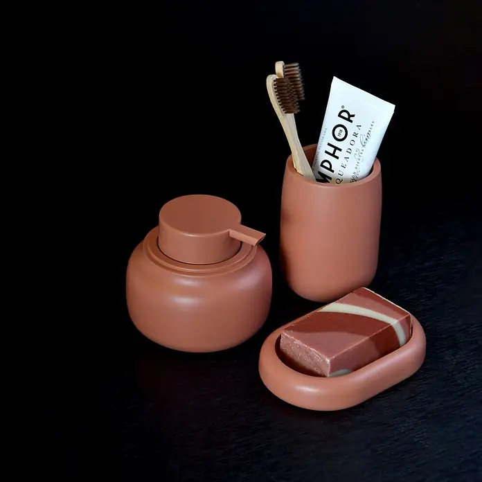 Spirella Portacepillos - Ø x Al: 8 cm x 10,5 mm, Terracota - Juego de baño de terracota mate: dispensador de jabón, vaso con cepillos de dientes y pasta, y jabonera con jabón de barra rayado, sobre superficie oscura.