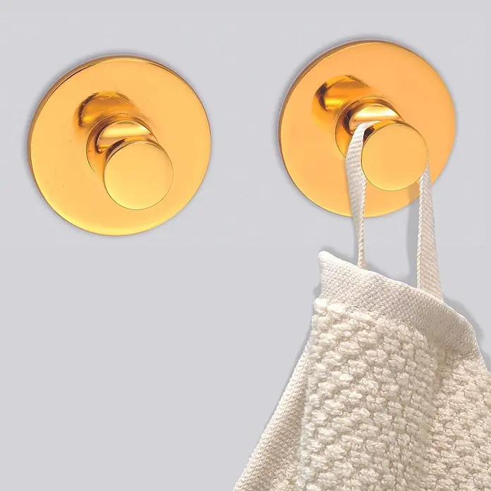 Spirella Colgador de baño Elsie - Oro, 2 ud. - Dos ganchos de pared dorados, uno sujetando una toalla texturizada color crema.