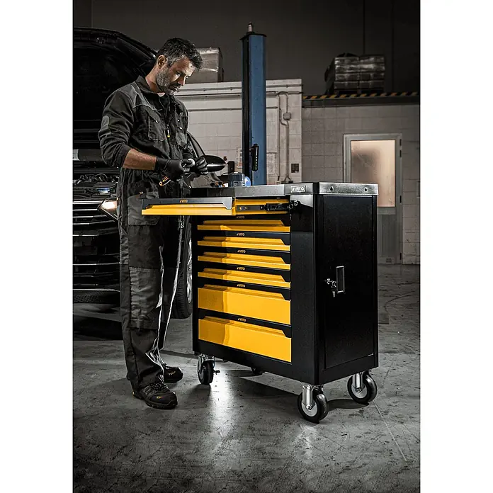 Vito Carro portaherramientas VITF7GA - L x An x Al: 465 x 770 x 970 mm, Número de cajones: 7 ud. - Carro de herramientas metálico negro y amarillo con ruedas y cajones abiertos, usado por un mecánico.