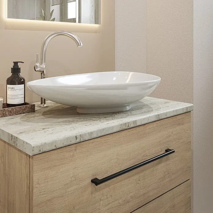 Wetwall Waschtischplatte Vanity HPL - 150 x 60 x 2,8 cm, Natural Travertine - Badezimmerunterschrank aus hellem Holz mit gemaserter Steinplatte, weißem Aufsatzwaschbecken und Chromarmatur. Eine braune Pumplastflasche steht auf einem Tablett.