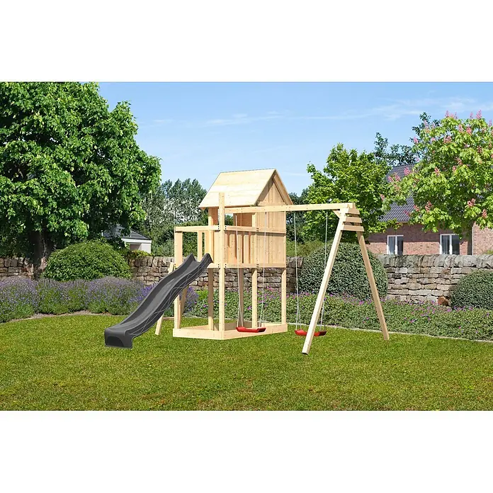 Karibu Spielhaus Set Frieda 59 - L x B x H: 107 x 107 x 291 cm, Holz, Naturbelassen - Hölzernes Spielhaus mit natürlicher Holzoberfläche, schwarzer Rutsche und zwei roten Schaukeln in einem grünen Garten.