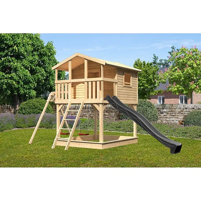 Karibu Spielhaus Benjamin Set 25 - L x B x H: 244 x 198 x 309 cm, Holz, Naturbelassen - Hölzernes Spielhaus mit Balkon, schwarzer Rutsche, roten Schaukeln und Sandkastenbereich, in einem sonnigen Garten.