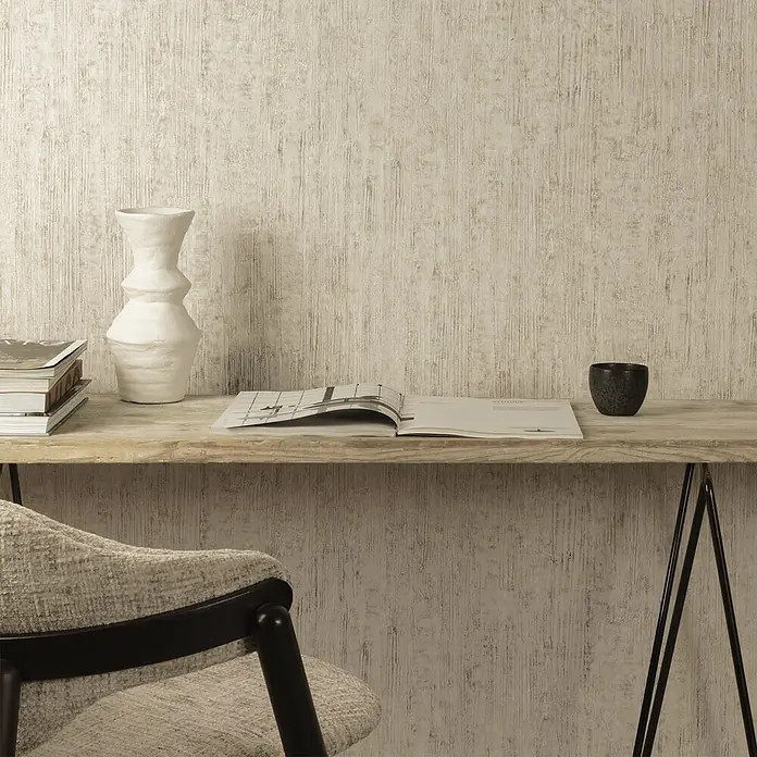 Grandeco Papel pintado de vinilo - Blanco, Efecto madera, 10 x 0,53 m - Papel pintado beige claro texturizado con sutiles rayas verticales, en una pared detrás de un escritorio y una silla de madera.