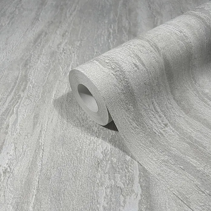 Marburg Papel pintado de vinilo - Gris, Efecto cemento, 10 x 0,53 m - Rollo de papel tapiz gris texturizado, parcialmente desenrollado, mostrando un sutil patrón jaspeado.