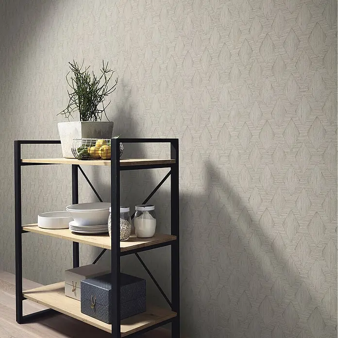 Erismann Papel pintado de vinilo Rombo - Beige, Gráfico, 10 x 0,53 m - Papel pintado beige claro con un sutil patrón geométrico, en una pared detrás de una estantería negra y de madera.