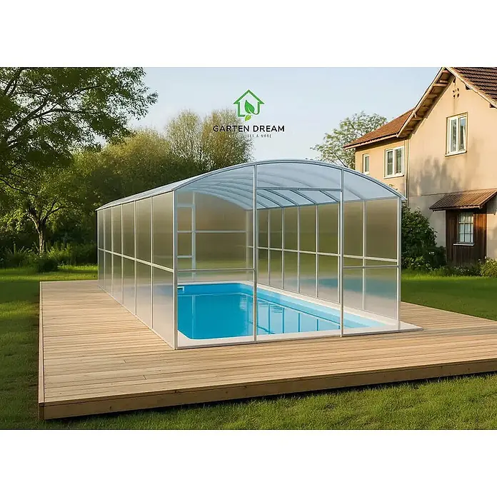 Garten Dream Gewächshaus Gabriela, 6mm Polycarbonat - Außenmaß inkl. Dachüberstand (B x T): 300 x 1.200 cm, 6 mm, Silber - Große transparente Poolüberdachung mit silbernem Rahmen über blauem Pool auf Holzterrasse im Garten.