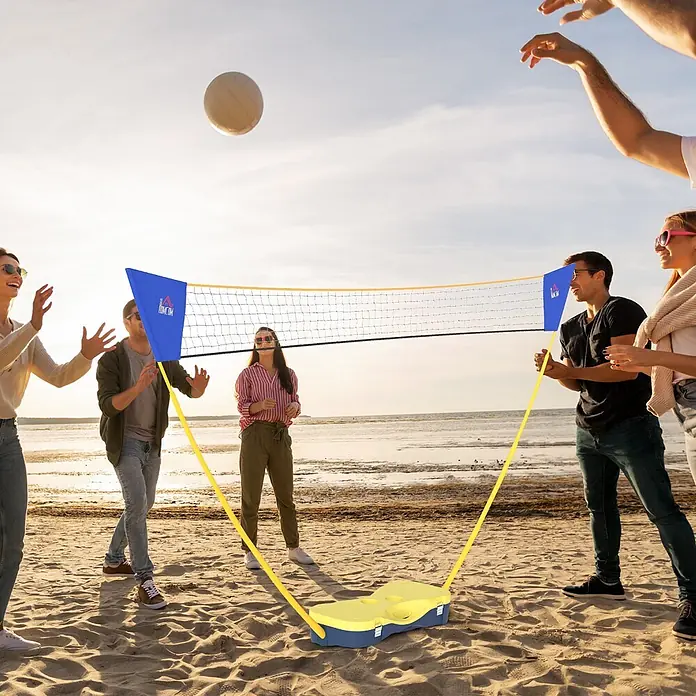 Homcom Badminton-Set - 286 x 33 x 157 cm, Kunststoff, Gelb, Blau - Tragbares blau-gelbes Volleyballnetz-Set, das von Personen an einem Sandstrand verwendet wird.