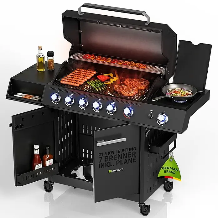 Juskys Gasgrill Tennessee - 21,5 kW, Anzahl Brenner: 6 Stk. - Schwarzer Gasgrill mit mehreren Brennern, kochendem Essen auf den Rosten und dem Seitenbrenner sowie offenen Staufächern darunter.