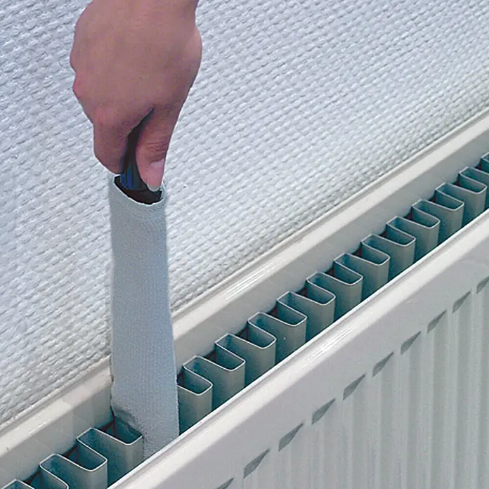 Heizkörper-Reiniger - Lang, Länge: 75 cm - Eine Hand reinigt mit einem Heizkörper-Reiniger einen weißen Heizkörper vor einer weißen Wand mit Struktur.