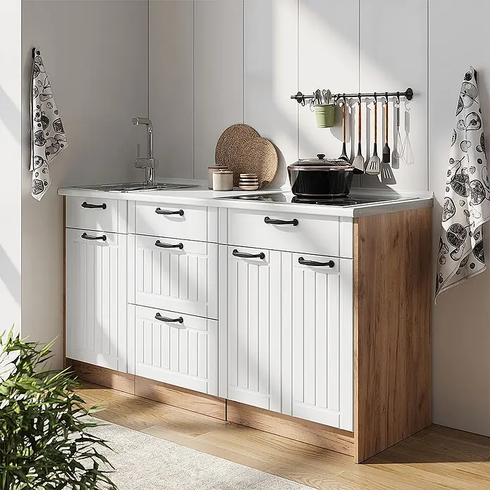 Vicco Küchenleerblock - Weiß Landhaus - Weißes Küchenunterschrank-Set mit schwarzen Griffen, integrierter Spüle und Kochfeld, Akzentpaneel aus hellem Holz, in einer Küche gezeigt.