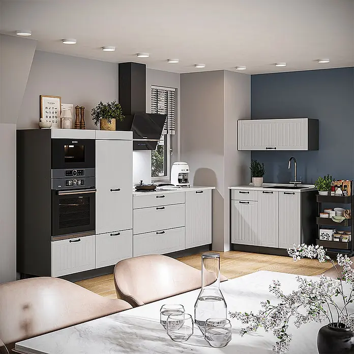 Vicco Küchenzeile - Breite: 280 cm, Weiß Landhaus, Ohne Elektrogeräte - Eine moderne Küche mit hellgrauen Paneelschranktüren, schwarzen Einbaugeräten und weißen Arbeitsplatten. Sie bietet viel Stauraum und ein schlankes Design.