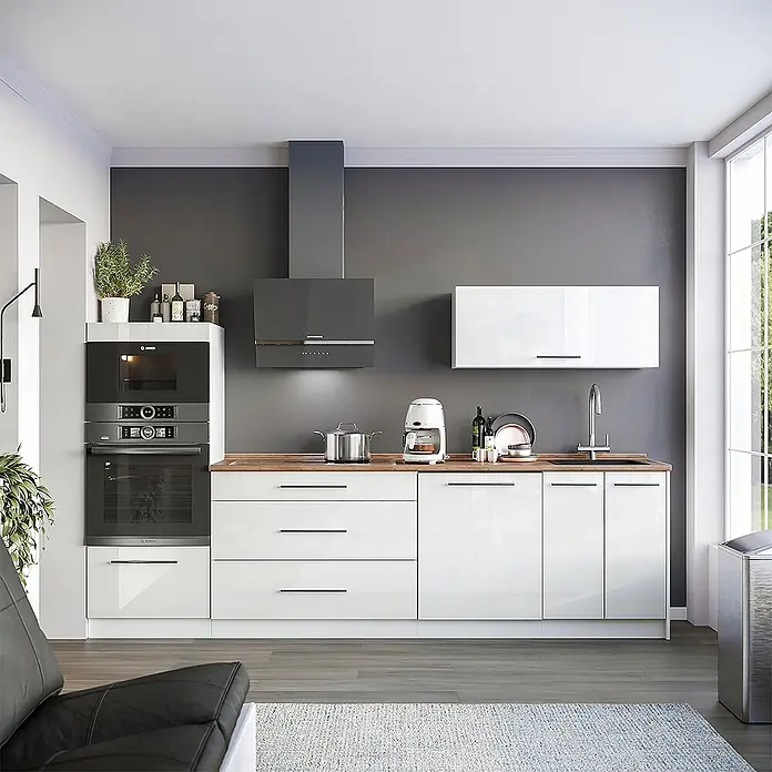 Vicco Küchenzeile - Weiß Hochglanz, Ohne Elektrogeräte - Moderne weiße Küche mit Hochglanzschränken, Holzarbeitsplatte, Einbaubacköfen und einer dunkelgrauen Dunstabzugshaube an einer Akzentwand.