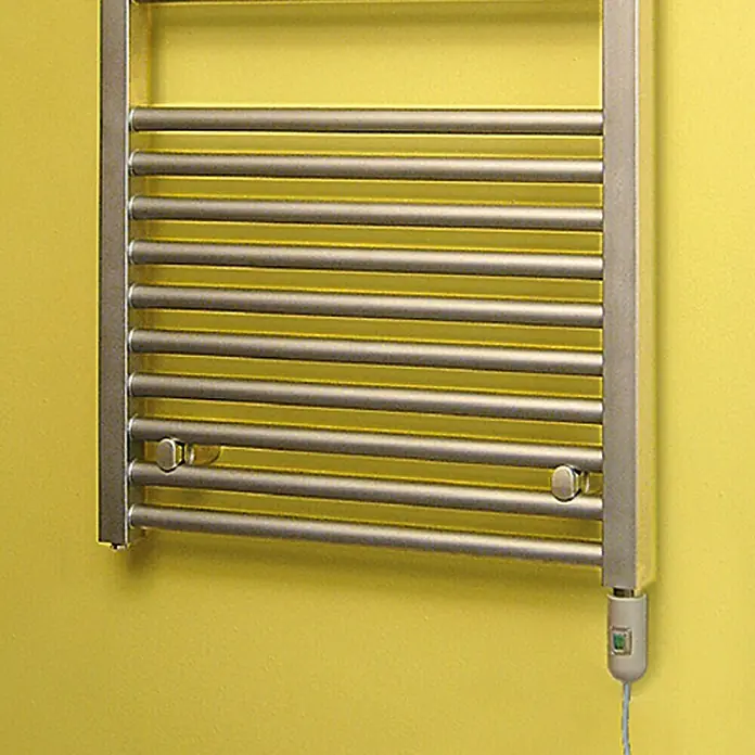 Admiral Elektro-Badheizkörper Trend - B x H: 600 x 1.165 mm - Nahaufnahme eines silbernen beheizten Handtuchhalters an einer gelben Wand, der Funktionalität und modernes Design vereint.
