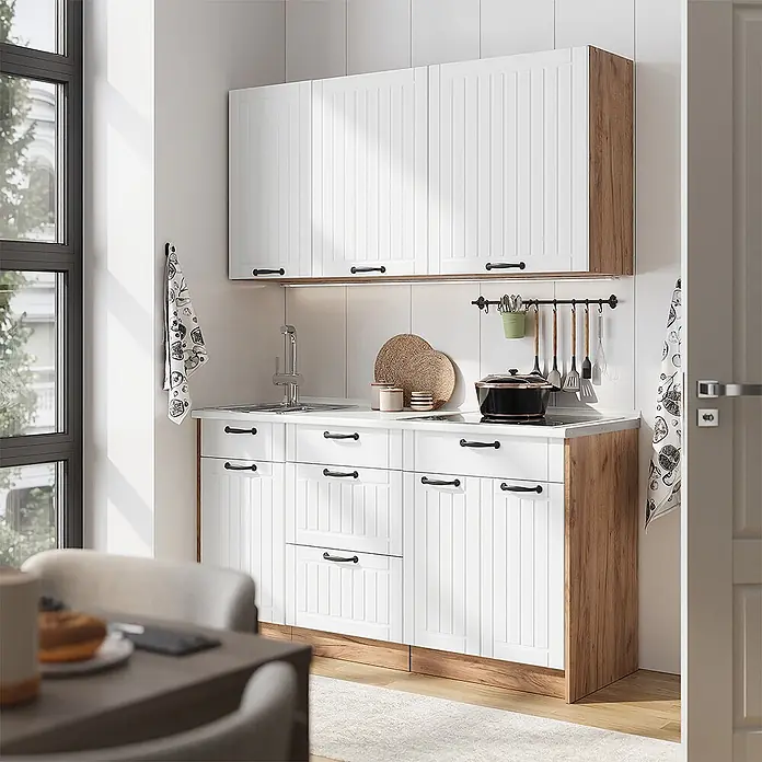 Vicco Singleküche - Weiß Landhaus, Mit AP Anthrazit - Weiße Küchenschränke mit Holzdetails, Spüle und Kochfeld, in einer hellen, modernen Küche.