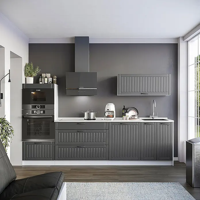 Vicco Küchenzeile - Dunkelgrau, Ohne Elektrogeräte - Dunkelgraue Küchenschränke mit vertikalen Paneeldetails, integriert in eine moderne Küche mit Geräten und einer weißen Arbeitsplatte.
