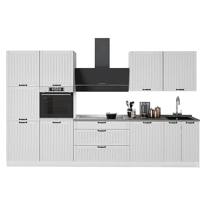 Vicco Küchenzeile - Breite: 340 cm, Weiß Landhaus, Ohne Elektrogeräte - Weiße Küche mit Lamellenschränken, schwarzen Griffen, Einbauofen, Induktionskochfeld, schwarzer Dunstabzugshaube und Spüle auf dunklen Arbeitsplatten.