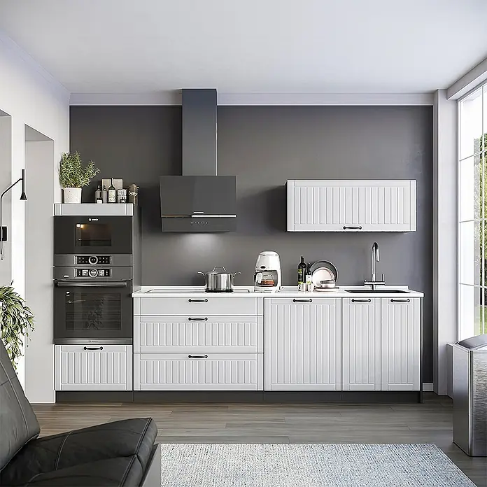 Vicco Küchenzeile - Breite: 280 cm, Weiß Landhaus, Ohne Elektrogeräte - Moderne weiße Küche mit geriffelten Schränken, schwarzen Griffen, integrierten Öfen und einer dunkelgrauen Dunstabzugshaube.