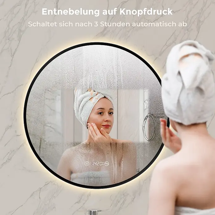 S'AFIELINA Lichtspiegel Luna Plus Ø 600 mm Schwarz - 60 x 60 cm - Runder LED-Antibeschlagspiegel mit schwarzem Rahmen und Digitalanzeige, der eine Frau nach dem Duschen spiegelt.