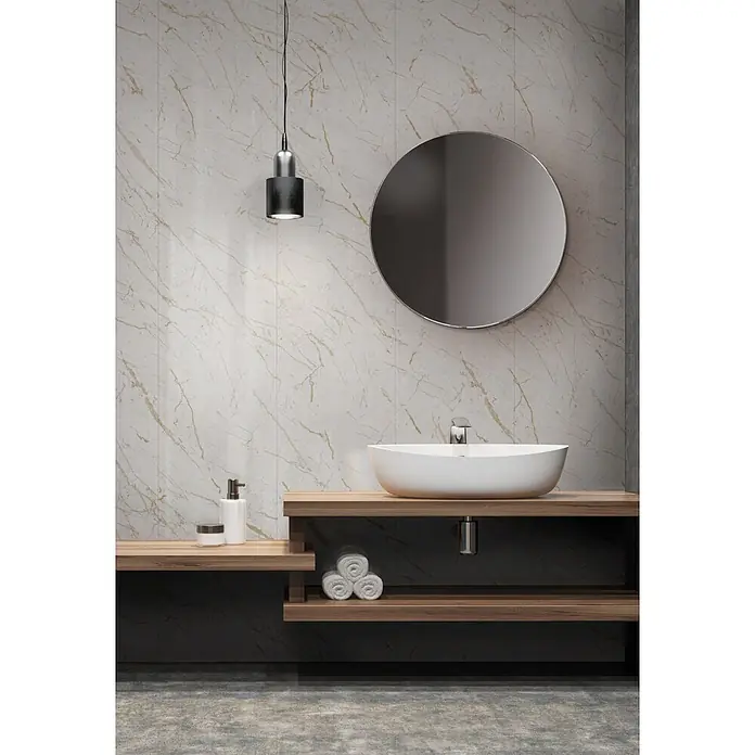 Grosfillex Wandpaneel Element 3D - Marble Calacatta, 2.600 x 375 x 8 mm - Modernes Badezimmer mit weißem Aufsatzwaschbecken auf Holzwaschtisch, rundem Spiegel und eleganter Hängelampe.