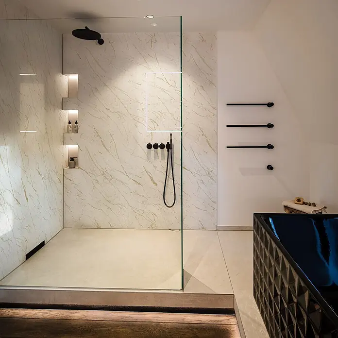 Grosfillex Wandpaneel Element 3D - Marble Calacatta, 2.600 x 375 x 8 mm - Moderne begehbare Dusche mit Marmoroptik-Wandpaneelen, mattschwarzen Armaturen und integrierten beleuchteten Nischen.