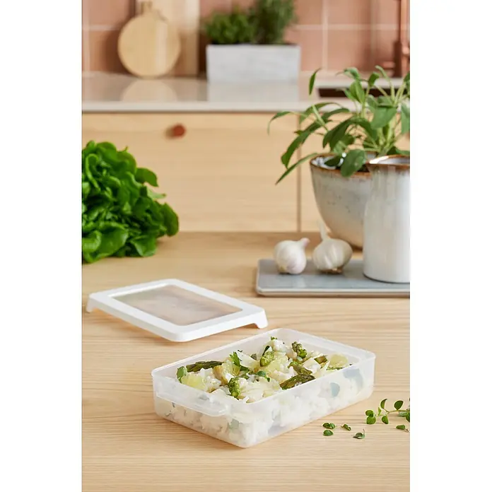 SmartStore Vorratsdose Snack - L x B x H: 18 x 12,5 x 4,5 cm, Kunststoff, Weiß - Rechteckige, transparente Kunststoff-Vorratsdose mit weißem Deckel, gefüllt mit Reis und Gemüse, auf einer Küchenarbeitsplatte aus Holz.