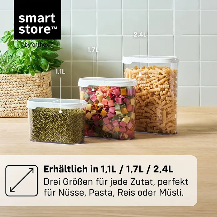SmartStore Vorratsdose Flip - L x B x H: 18,5 x 9,5 x 17 cm, Kunststoff, Weiß - Drei transparente Smartstore Vorratsdosen mit weißen Deckeln, gefüllt mit Lebensmitteln (Bohnen, Pasta), in 1.1L, 1.7L, 2.4L auf einer Küchenzeile.