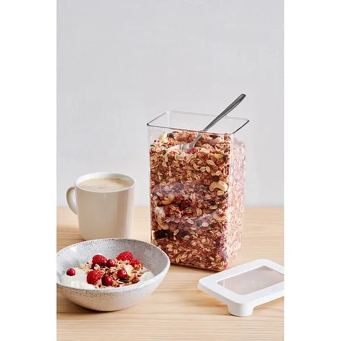 SmartStore Vorratsdose Vision - L x B x H: 12,5 x 9 x 20 cm, Kunststoff, Weiß - Klarer, rechteckiger Lebensmittelbehälter mit Müsli und Löffel, daneben eine Schale Joghurt mit Beeren und eine Kaffeetasse.