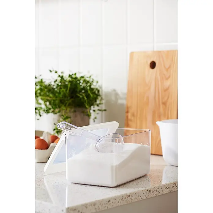 SmartStore Vorratsdose Vision - L x B x H: 18 x 12,5 x 10 cm, Kunststoff, Weiß - Klarer rechteckiger Behälter mit weißem Kristallzucker und transparentem Messlöffel auf einer Küchenarbeitsplatte.