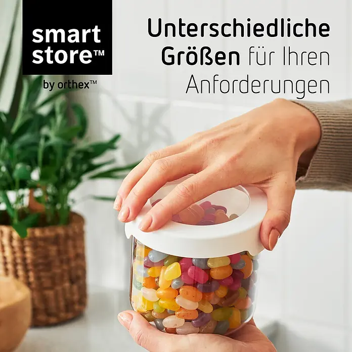 SmartStore Vorratsdose Vision - Ø x H: 11,5 x 10 cm, Kunststoff, Weiß - Transparenter SmartStore-Behälter mit weißem Deckel, gefüllt mit bunten Geleebohnen, von Händen gehalten.