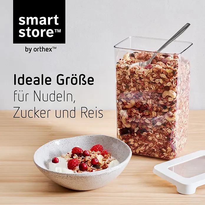 SmartStore Vorratsdose Vision - L x B x H: 12,5 x 9 x 20 cm, Kunststoff, Weiß - Klarer rechteckiger Lebensmittelbehälter gefüllt mit Müsli, daneben ein weißer Deckel. Eine Schüssel Joghurt mit Beeren steht auf dem Holztisch.