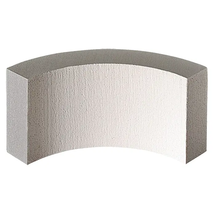 Ytong Segmentstein - 600 x 100 x 200 mm, Winkel: 90 ° - Ein weißer, gebogener Quader aus Beton mit einer groben Textur. Das Design erinnert an moderne Architektur und Stabilität.
