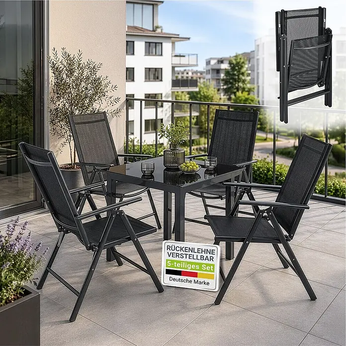 Juskys Gartentisch-Set Milano - L x B x H: 80 x 80 x 74 cm, Gestell: Pulverbeschichtetes Aluminium; Geflecht: Textilgewebe (100% Polyester, PVC-ummantelt); Tischplatten: 5mm Sicherheitsglas - Schwarzes 5-teiliges Klapp-Gartenset mit Tisch und vier Stühlen mit verstellbarer Rückenlehne auf einem Balkon. Ein Stuhl ist zusammengeklappt zu sehen.