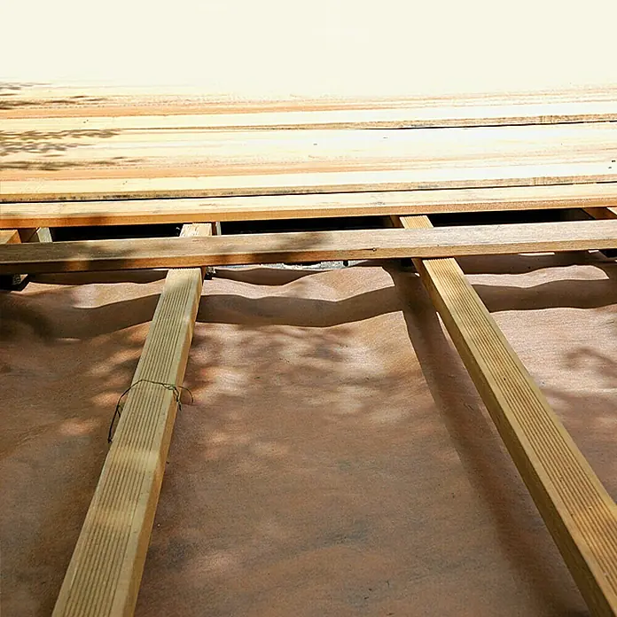 Gardol Untervlies - Polypropylen, 3 x 2 m - Nahaufnahme eines Holzdecks im Bau, die Balkenstruktur und die darunterliegende Schutzschicht sind gut sichtbar.