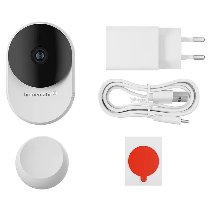 Homematic IP Innenkamera Smart Home HmIP-CI-B - Weiß - Weiße Homematic IP Kamera mit schwarzer Front, weißem Netzteil, USB-Kabel, Montageplatte und rotem Klebepad.
