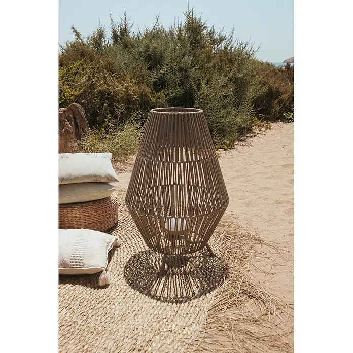 New Garden Conta Lámpara de pie para exterior 70 - 9 W, Blanco cálido, 48 x 48 x 72 cm, Con bombillas - Lámpara exterior grande de mimbre marrón en una estera con cojines sobre arena, entre arbustos, junto al mar.