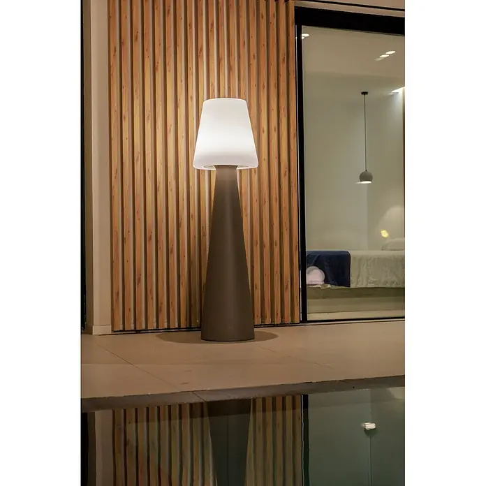 New Garden Lámpara de pie con batería Lola 165 Taupe - Taupe, Altura: 165 cm, Blanco neutro - Lámpara de pie alta gris oscuro y blanca brillante al aire libre junto a una piscina, ofreciendo luz ambiental.