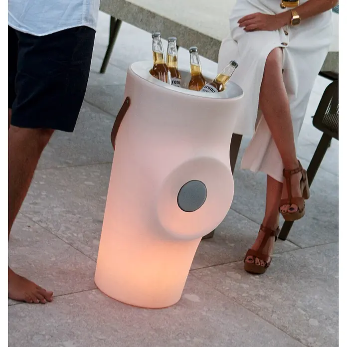 New Garden Lámpara para exterior Woody 70 - Blanco, 38 x 36 x 70 cm, RGB, Altavoz Bluetooth - Nevera iluminada de color claro con altavoz integrado, conteniendo botellas de cerveza.