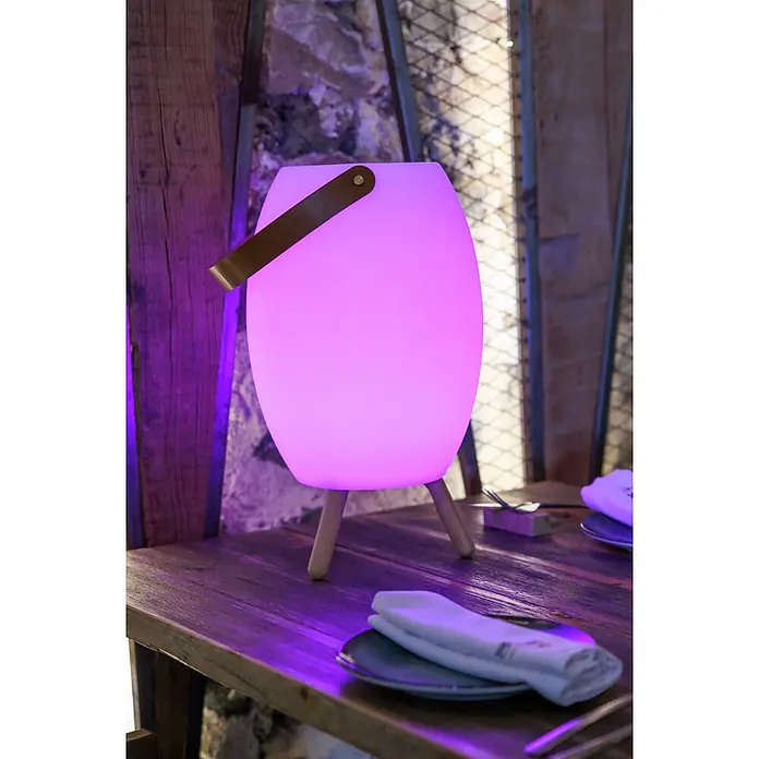 New Garden Lámpara para exterior con altavoz Apolo 45 - 6 W, Blanco, Ø x Al: 24 x 40,5 cm, RGBW, Altavoz - Lámpara de mesa morada brillante con asa de cuero marrón y patas de madera, iluminando un ajuste de mesa.